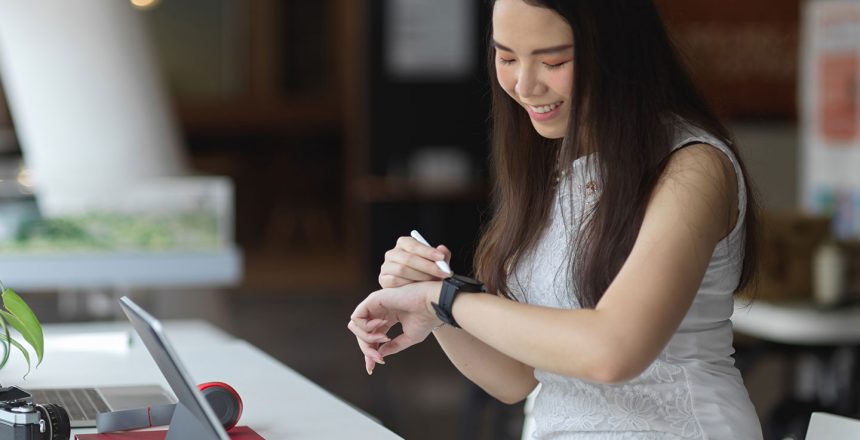 portrait-female-looking-smartwatch-while-working-co-working-space